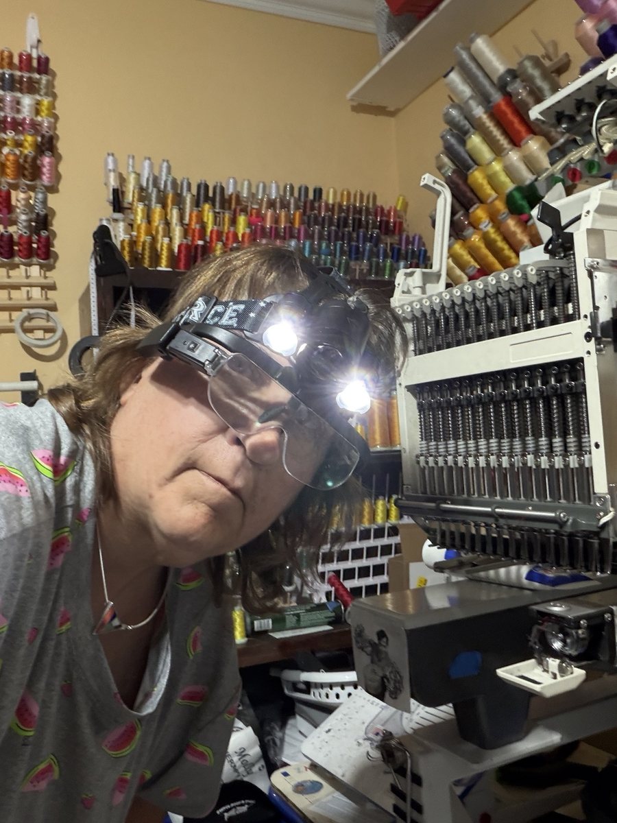 Marian wearing a lighted headband while working on an embroidery machine